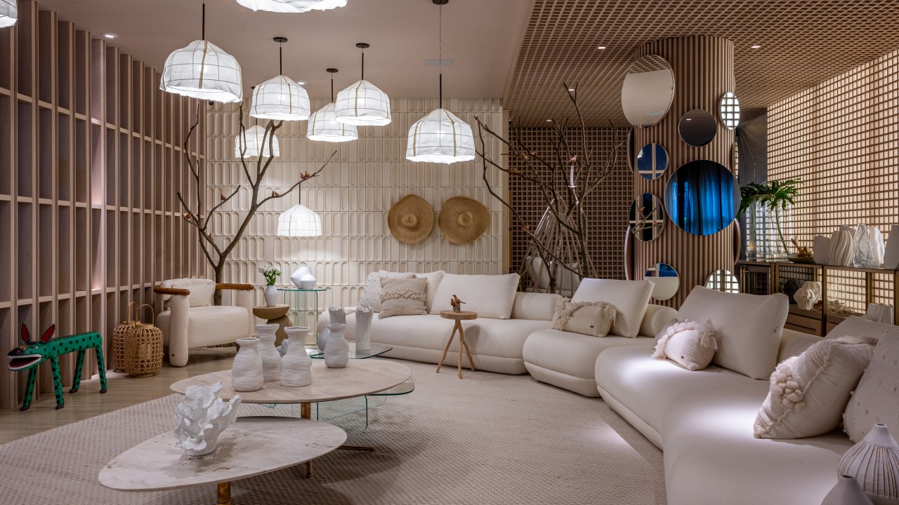 Jogo de luz e sombra: madeiras em muxarabi são destaque neste ambiente. Projeto de Carla Felippi. Na foto, sala com luminárias, peças de decoração e sofá extenso