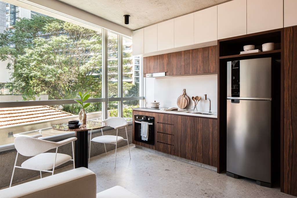 Painéis em madeira pau ferro contrastam com laje de concreto neste apê