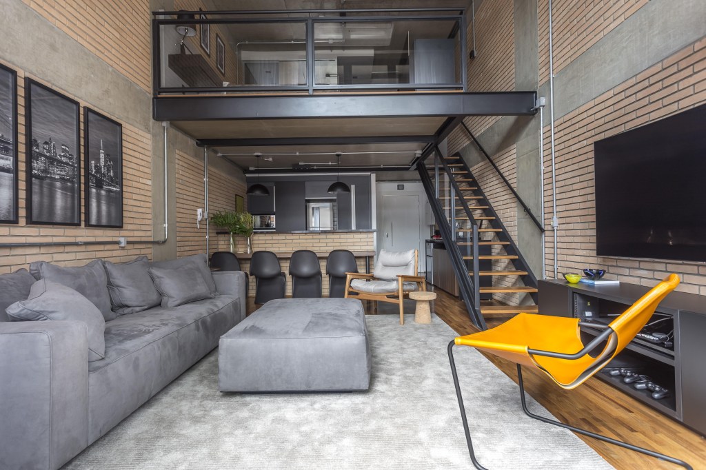 Como escolher e decorar lofts? Projeto de Korman Arquitetos. Na foto, loft em estilo industrial com decoração cinza e preta