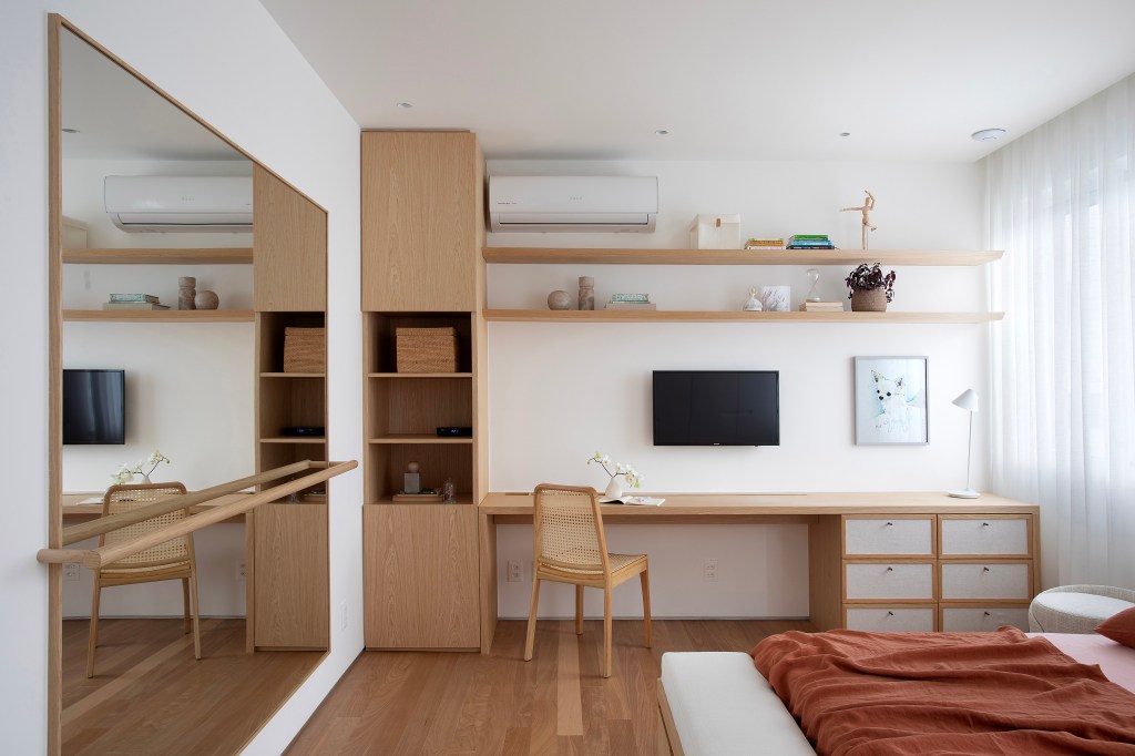Hall de entrada minimalista com espelho orgânico embutido em painel dá boas vindas em apê. Projeto de Fato Estúdio. Na foto, quarto, espelho, home office.